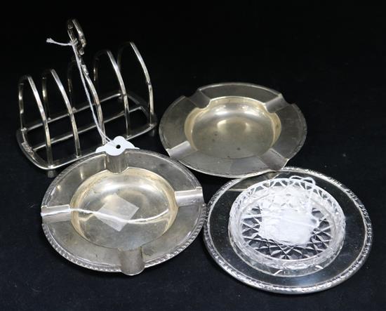 A silver toast rack, Goldsmiths & Silversmith Co Ltd, a pair of silver ashtrays and a cut glass butter dish on silver stand, 15.5oz